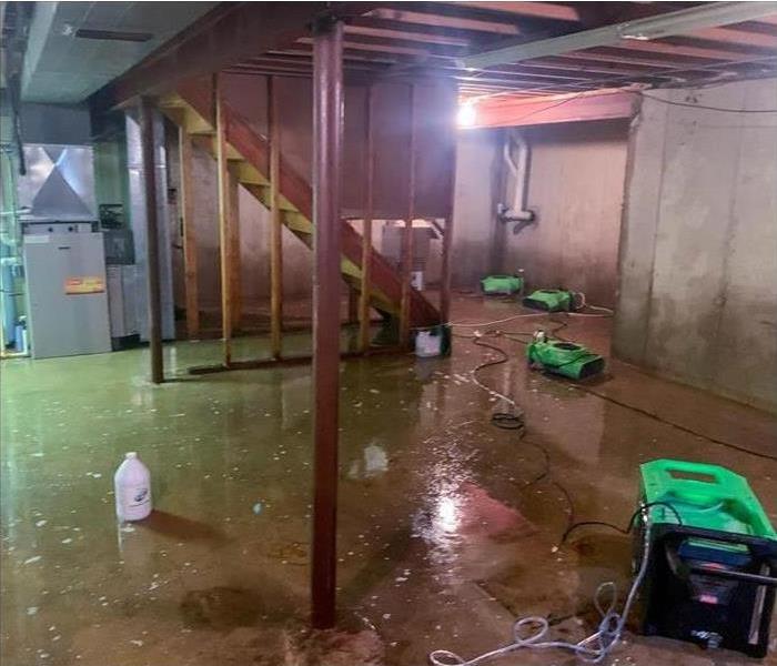 Flooded basement with drying equipment placed in damaged area.